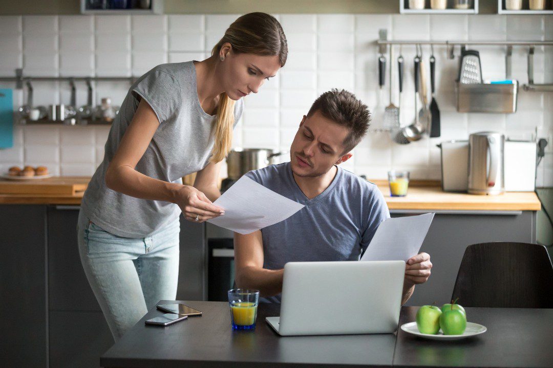 Man and woman look over bills.